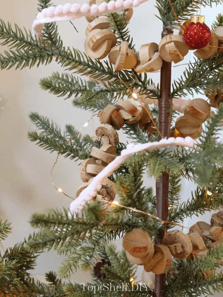 Put your wine cork stash to work this holiday season making wine cork Christmas trees and wine cork garlands. Create a rustic snowy woods table spread using cone trees made from natural elements. #conetrees #diyconetrees #winecorks #winecorkprojects 